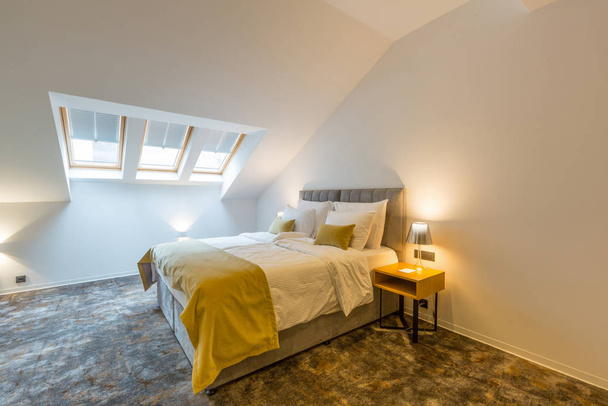 Interior of a loft double bed hotel bedroom - Фото, изображение