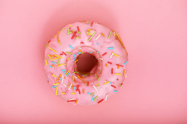 Pink donut on a pink background, minimalism concept, color game.background, copy space - Fotoğraf, Görsel