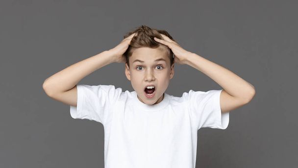 Emocjonalny nastolatek krzyczy i chwyta włosy w panice - Zdjęcie, obraz