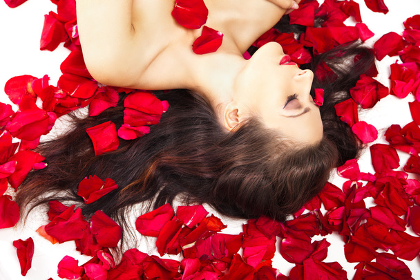 piękna kobieta w płatki czerwonych róż na białym - Zdjęcie, obraz