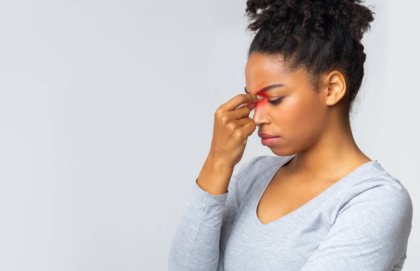Traurige junge Frau berührt ihren Nasenrücken - Foto, Bild