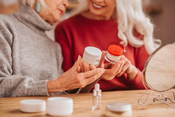 Two good-looking elderly women talking about skin care - Photo, image
