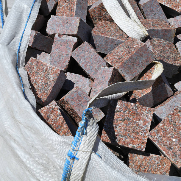 Een flexibele tussencontainer (Fibc) met granieten blokkade op een bouwplaats. - Foto, afbeelding