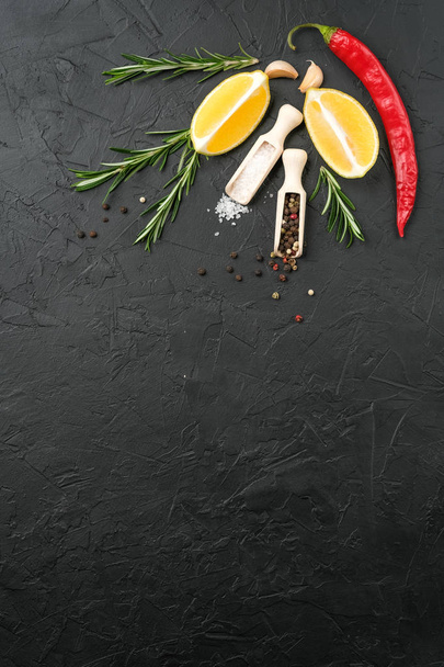 Selection of spices, herbs and lemon. Ingredients for cooking. Food background on dark stone table. Top view copy space - Fotoğraf, Görsel