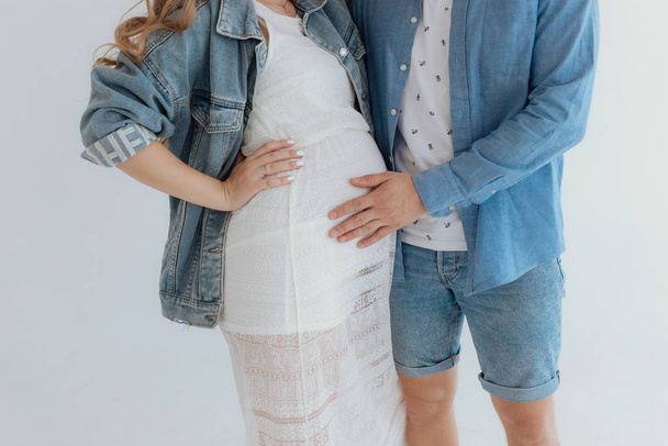 Shot of pretty young pregnant couple in the white room at home. - Photo, Image