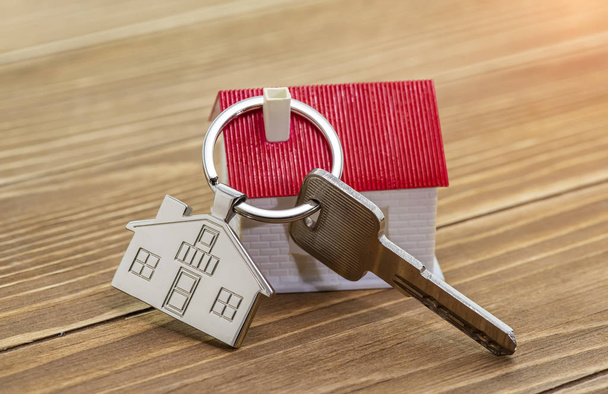 porte-clés avec symbole de maison et clés sur fond en bois, concept immobilier - Photo, image