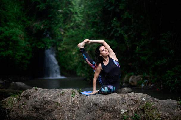 Yoga ve meditasyon doğada var. Nehir kenarında pratik yapan kadın - Fotoğraf, Görsel