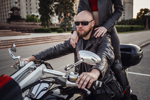 Beautiful couple on a cool motorcycle against Moscow - 写真・画像