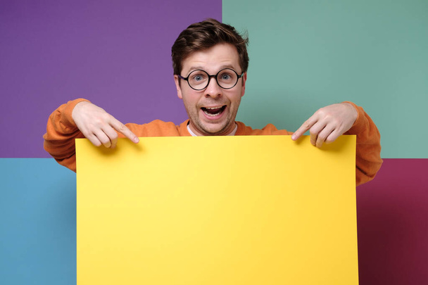 handsome guy in glasses showing empty yellow copyspace - Photo, Image