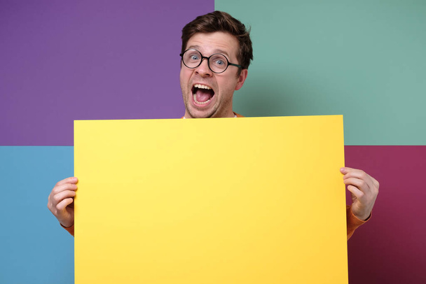 guapo chico en gafas mostrando vacío copyspace amarillo
 - Foto, imagen