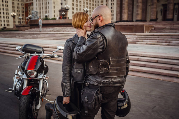 Beautiful couple on a cool motorcycle against Moscow - Fotó, kép
