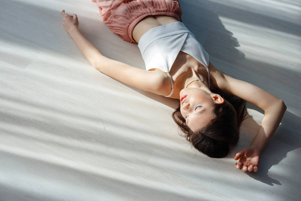 Красивая сексуальная брюнетка лежит на полу. красивый свет из окна
 - Фото, изображение