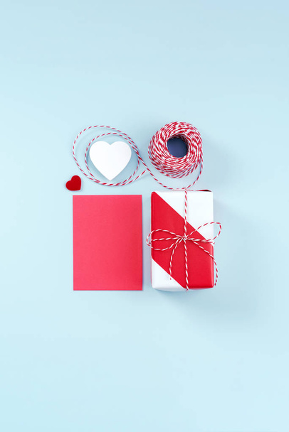 バレンタインデー、プロモーションのための母の日のアートデザインコンセプト-赤、白の包装ギフトボックスパステルライトブルーの背景に隔離され、フラットレイアウト、トップビュー. - 写真・画像
