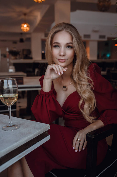 Elegant lady with glass of wine alone in restaurant - Φωτογραφία, εικόνα