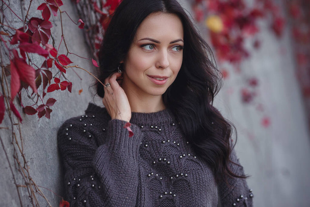Girl on background wall with red autumn leaves. - Фото, зображення