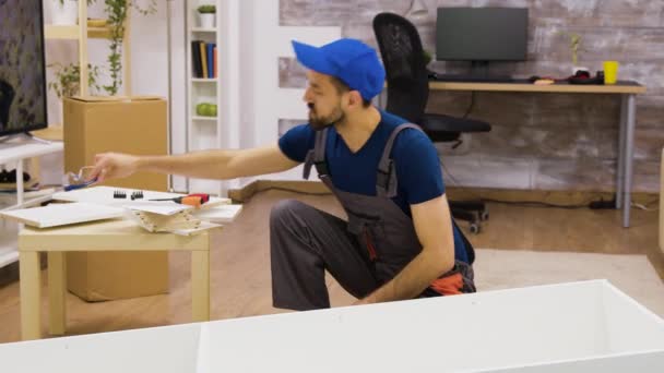 Male worker wearing protection glasses before furniture assembly - Filmmaterial, Video