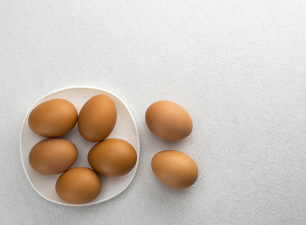 Αυγά σε λευκό πιάτο και στη συνέχεια να θέσει στο πάτωμα. - Φωτογραφία, εικόνα