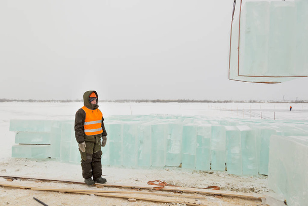 Slinger em capacete laranja na expedição de blocos de gelo
 - Foto, Imagem