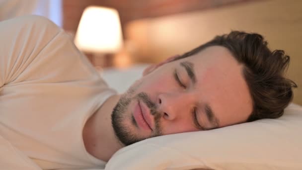 Portret van een knappe jongeman met een dutje in bed - Video