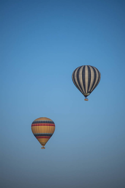 Capadócia, Turquia, Europa, 07 / 08 / 2019: um balão de ar quente tradicional flutuando após o amanhecer no céu sobre o vale de Cavusin, na região histórica da Anatólia Central, rico em maravilhas naturais excepcionais
 - Foto, Imagem