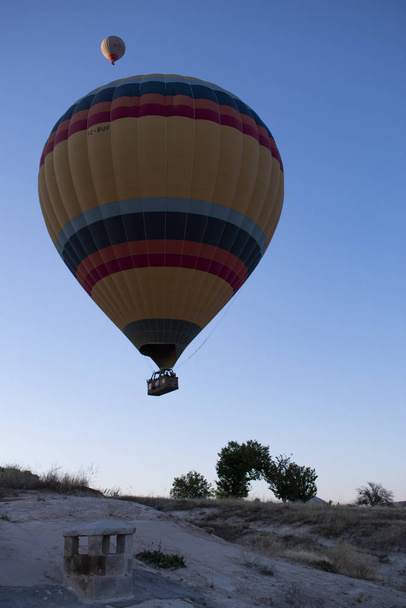 Cappadocia, Turecko, Evropa, 07 / 08 / 2019: tradiční horkovzdušné balóny plovoucí za úsvitu na obloze nad údolím Cavusin v historické oblasti ve střední Anatolii bohaté na výjimečné přírodní zázraky - Fotografie, Obrázek