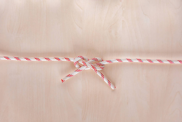 Carrick bend ship knot on wooden background - 写真・画像