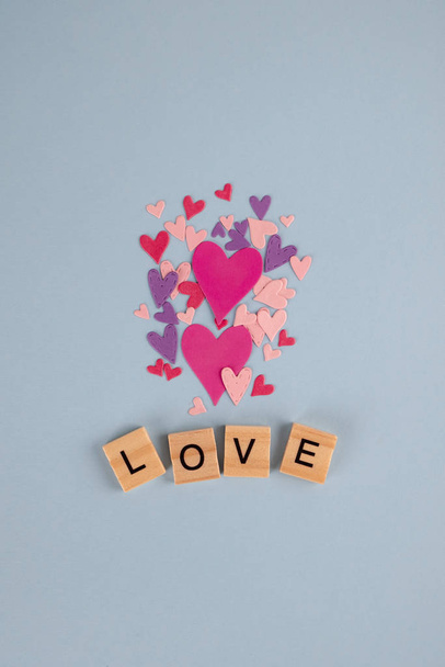 Slovo láska a srdce na modrém pozadí. Na Valentýna. Valentýn, Den matek, Den žen, svatební přání. - Fotografie, Obrázek