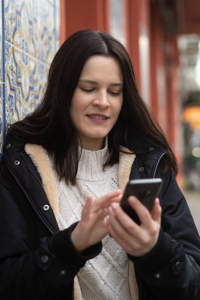 Gyönyörű barna fiatal nő használja a telefonját - Fotó, kép