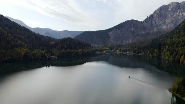 Luftaufnahme von schönen alpinen See ritsa Speedboot schwimmenden Sommer, Blick von oben auf herrlichen See ritsa zwischen Bergen im Nationalpark, klares Wasser, unberührte Natur. - Filmmaterial, Video