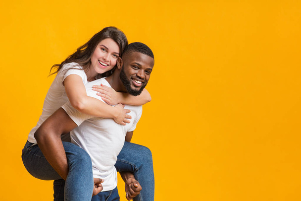 retrato de romántico negro hombre piggybacking su novia
 - Foto, Imagen