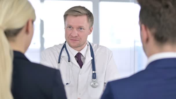 Portret van professionele mannelijke arts doet overleg met patiënten - Video
