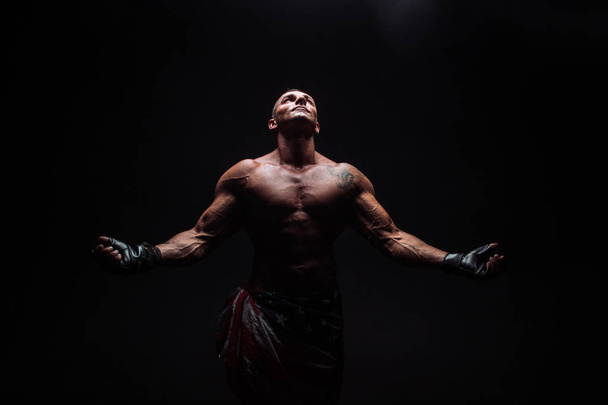 Construtor de corpo masculino com uma construção atlética em um fundo escuro. atleta, exercício, saúde, poder, força, homem
, - Foto, Imagem