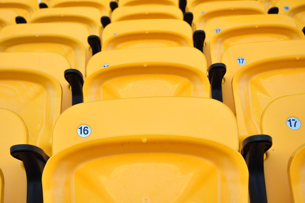 Ряд желтое сиденье на футбольном стадионе
 - Фото, изображение