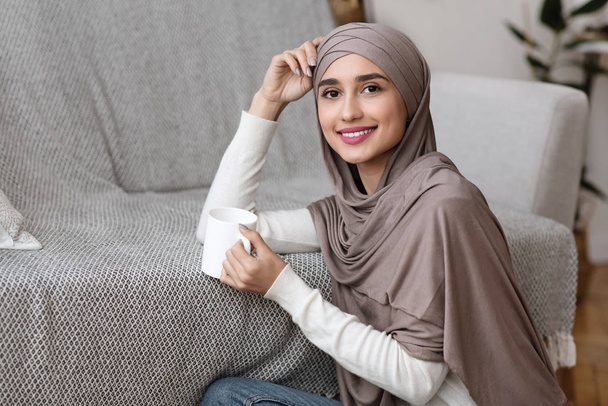 Relaxed Muslim Girl Sitting On Floor With Cup Of Tea - Foto, imagen