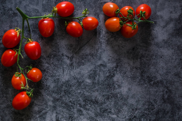 fresh tasty cherry tomatoes on dark stone background with copy s - Photo, Image