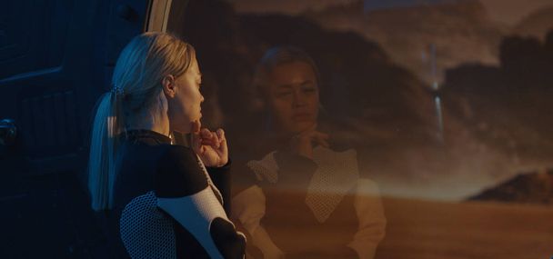 Жіночий астронавт дивиться з вікна бази Марса. - Фото, зображення
