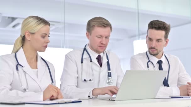 Poważny zespół lekarzy pracujących razem na laptopie  - Materiał filmowy, wideo