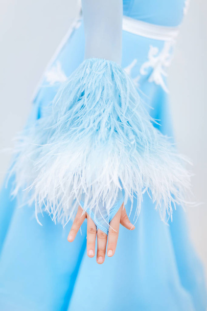 girl in a ball gown of blue sky color with white feathers on a white background - Photo, Image
