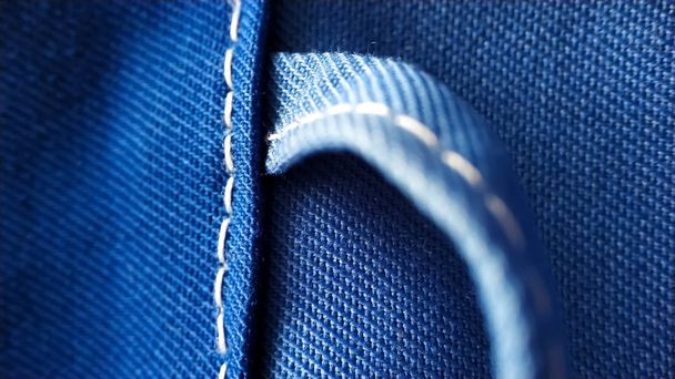 Цикл на синьому робочому одязі. робочий одяг крупним планом макро шов, стяжка, текстура
 - Фото, зображення