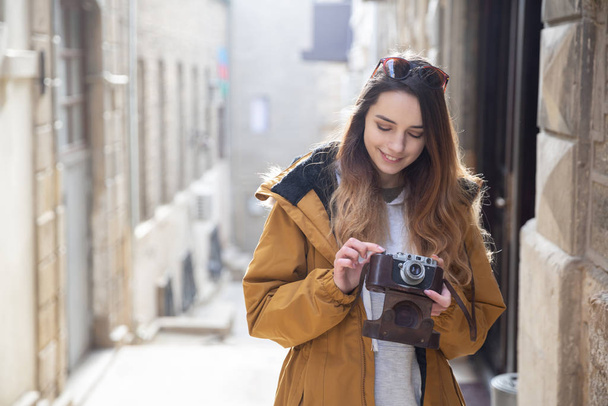 Foto de una joven turista explorando las calles de Bakú. Moody fotos de adolescente visitando la ciudad vieja y tomando fotos de la ciudad
. - Foto, imagen