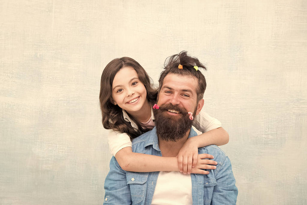 Changing the world one man at a time. Little girl hug bearded man. Small child and happy man with funny hairstyle. Caucasian man and cute daughter. Family barbershop that cares about you - Photo, image