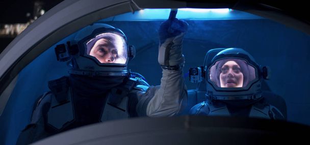 Astronauta a olhar pela janela da nave espacial
 - Foto, Imagem