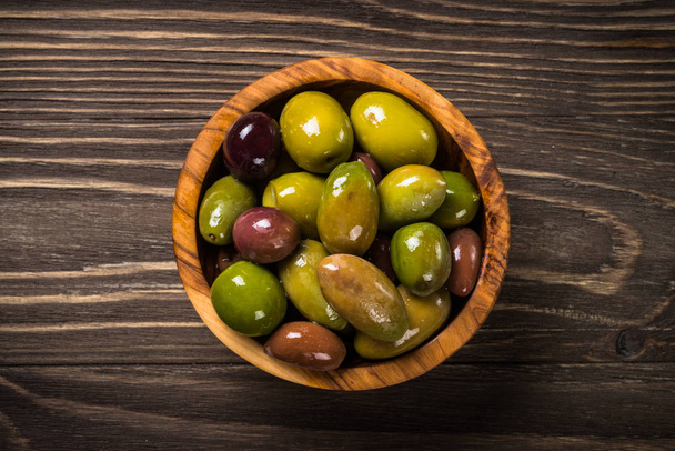 Black and green olives on wooden table. - Photo, Image
