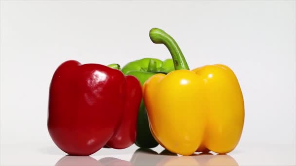 Žlutá červená a zelená paprika se stínem na bílém stole, otáčení 360 stupňů. Bílé pozadí.Ultra vysoké rozlišení 3840x2160.4k rozlišení - Záběry, video