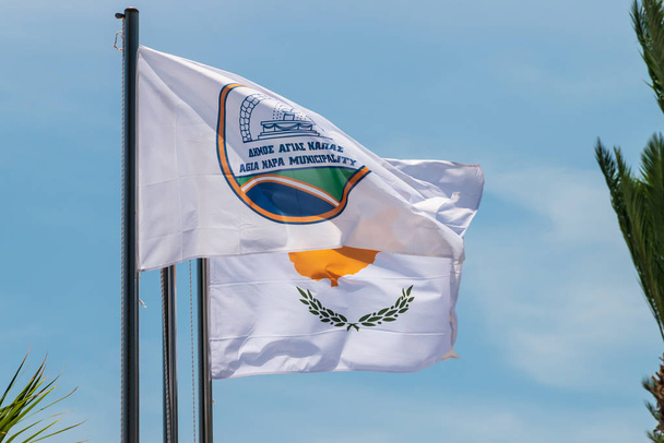 The flag of Agia Napa municipality and the flag of Cyprus. Flags on the flagpole and the stereet lamp post. The wind inflates the flag. - Fotografie, Obrázek