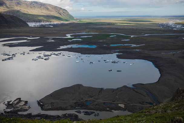 Η ακτή της νότιας ακτής της Ισλανδίας, σε απόσταση η ακτογραμμή του Ατλαντικού Ωκεανού, λιωμένες λίμνες μορφή πάγου. - Φωτογραφία, εικόνα
