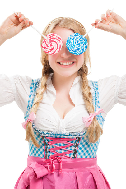 Bavarian woman in dirndl, holding lollipop. - Фото, зображення