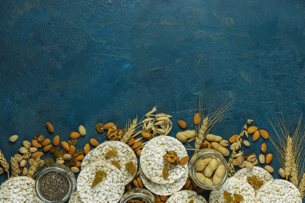 Американець набивав рисові коржики. Здорові закуски з вухами пшениці на класичній блакитній бетонній поверхні, вид зверху, плоска поверхня, копіювальний простір для тексту. Колір 2020 року. Класичний синій колір, харчова мода - Фото, зображення