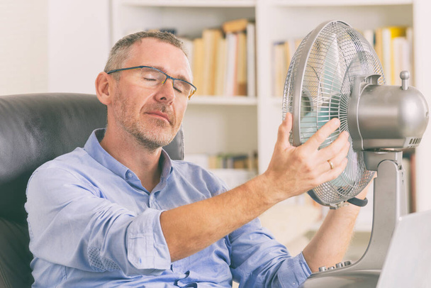 Mann leidet unter Hitze im Büro oder zu Hause - Foto, Bild