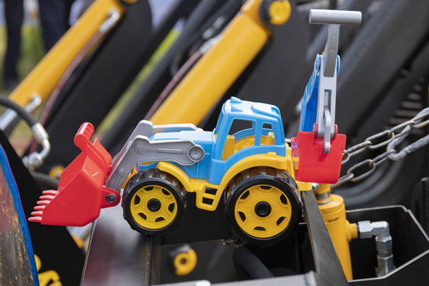 Excavator toy standing on a metal construction on a sunny day. - Photo, Image